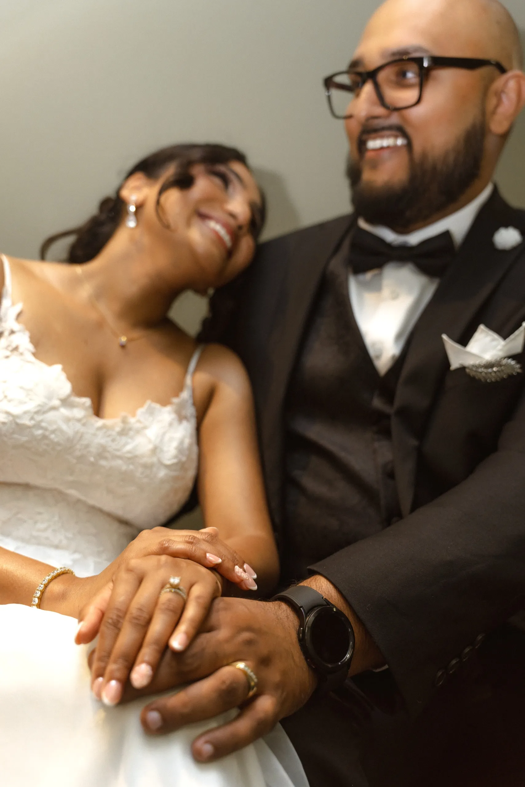 The couple's hands clasped together with both wedding rings, by AD Photography