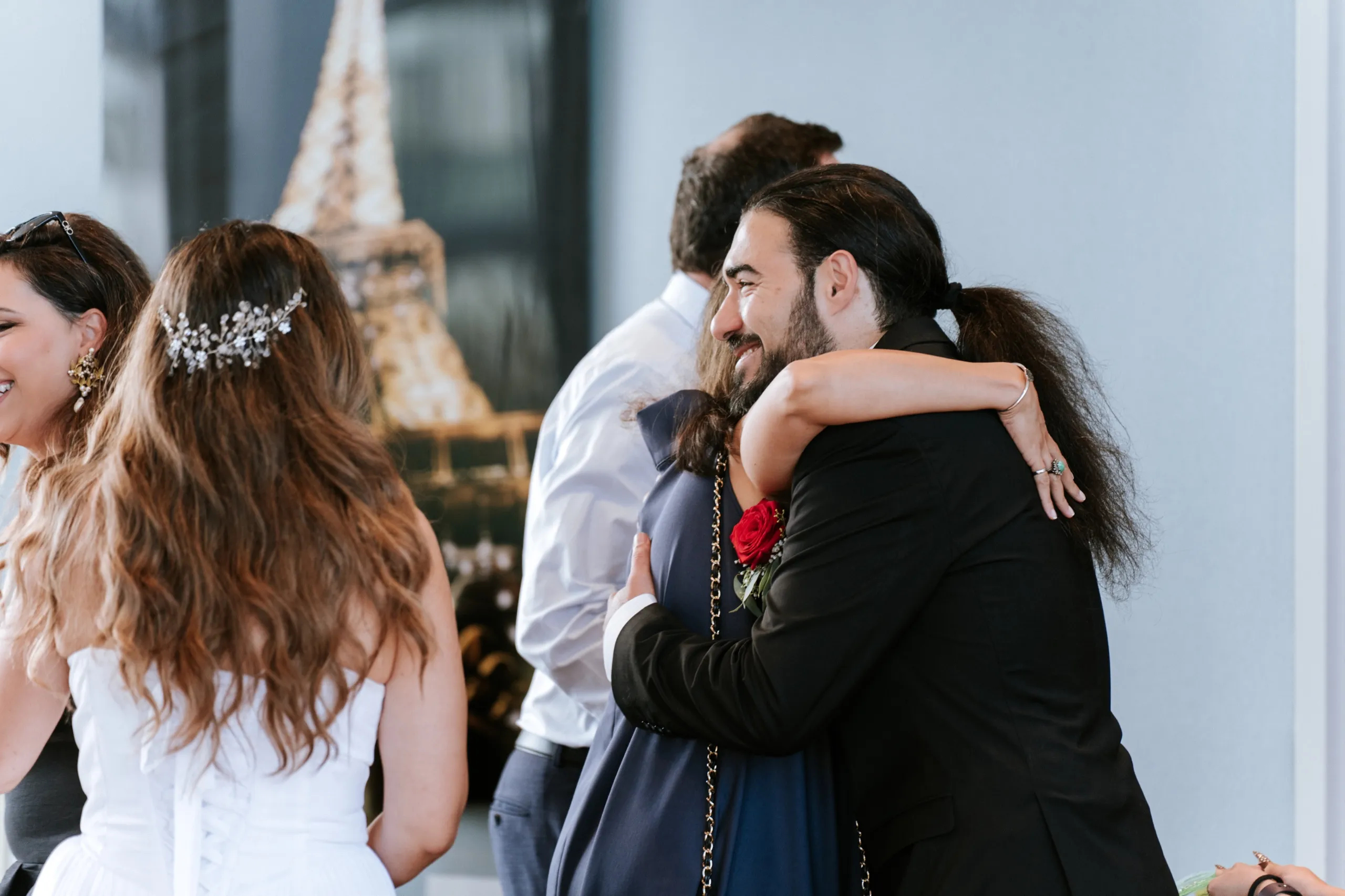 Moe pulls a guest into a hug as the room fills for the anniversary celebration, by AD Photography