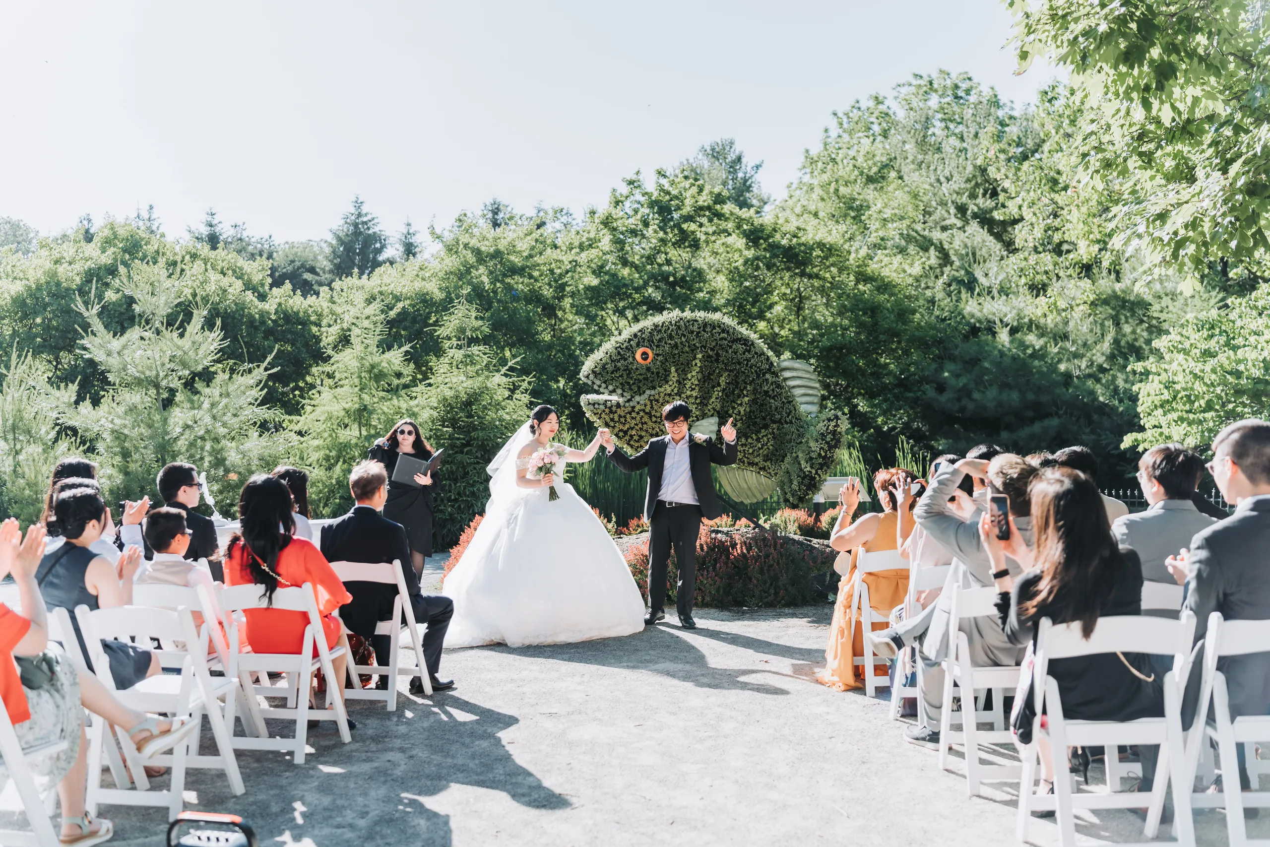 Micheal raising his arm as the couple recess down the garden aisle to cheering guests in Niagara Falls, by AD Photography
