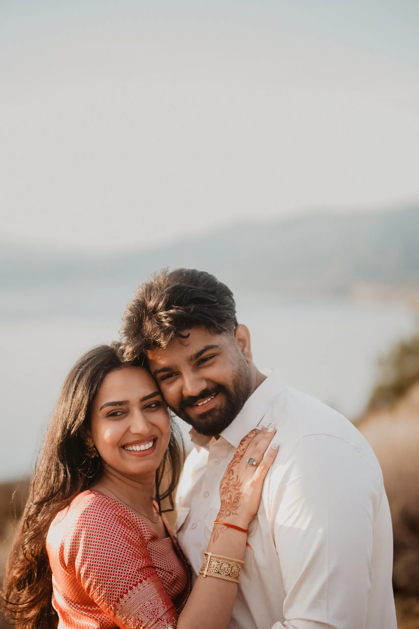 Mehak and Kamal cheek to cheek above the water, her henna hand on his chest, by AD Photography