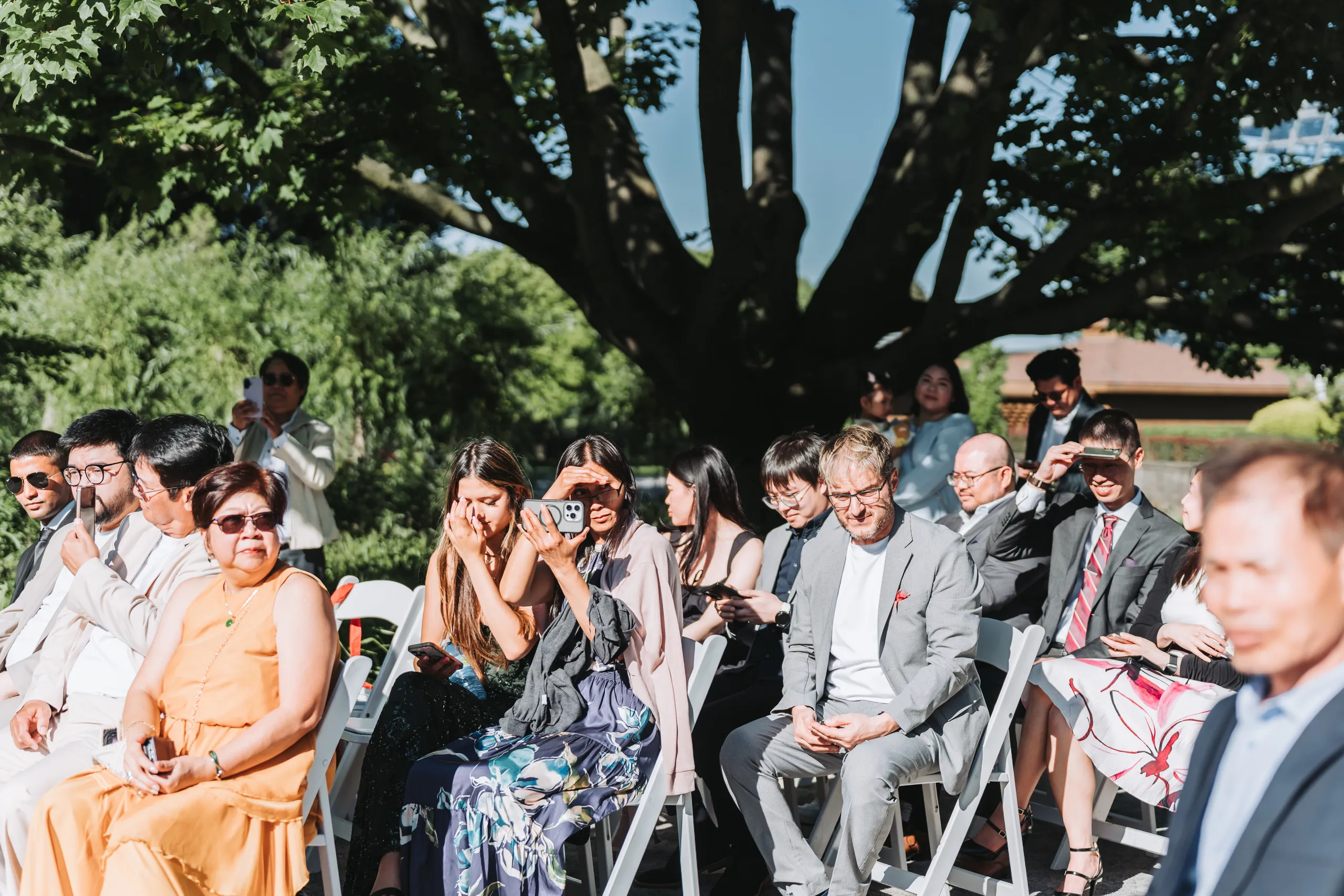 A wedding guest covering her mouth, visibly moved during the Botanical Gardens ceremony, by AD Photography