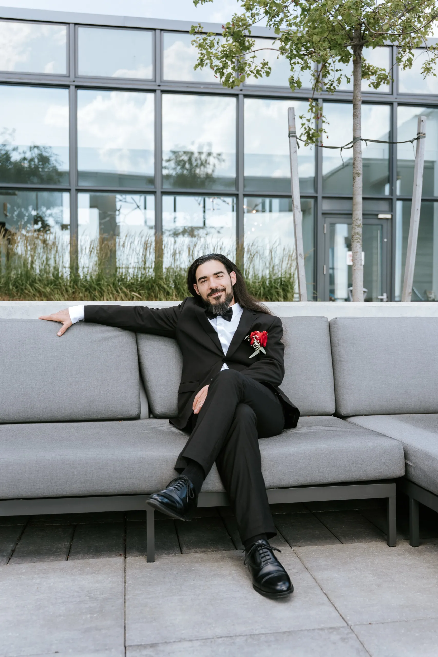 Moe sits alone on the grey terrace couch in his black tuxedo above Maple, by AD Photography