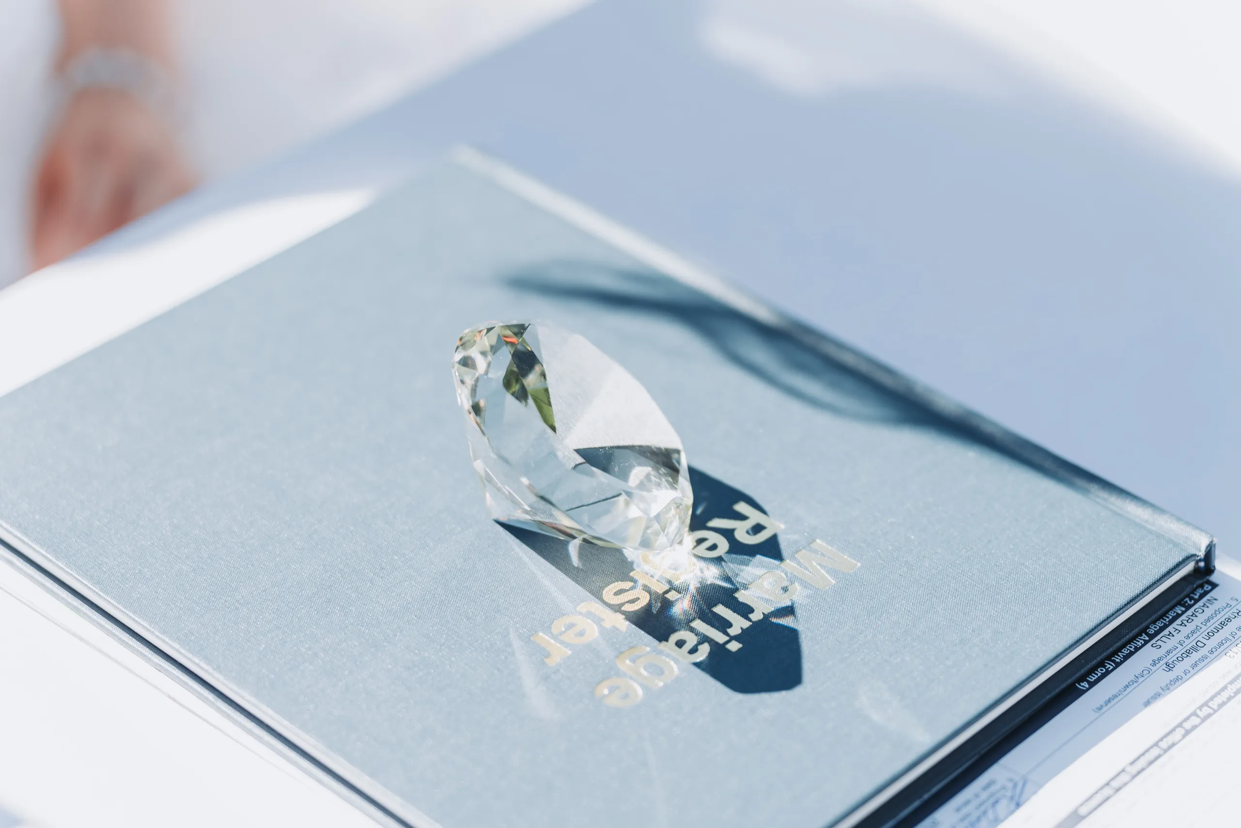 Sunlight refracting through Karen's diamond ring onto the marriage register in Niagara Falls, by AD Photography