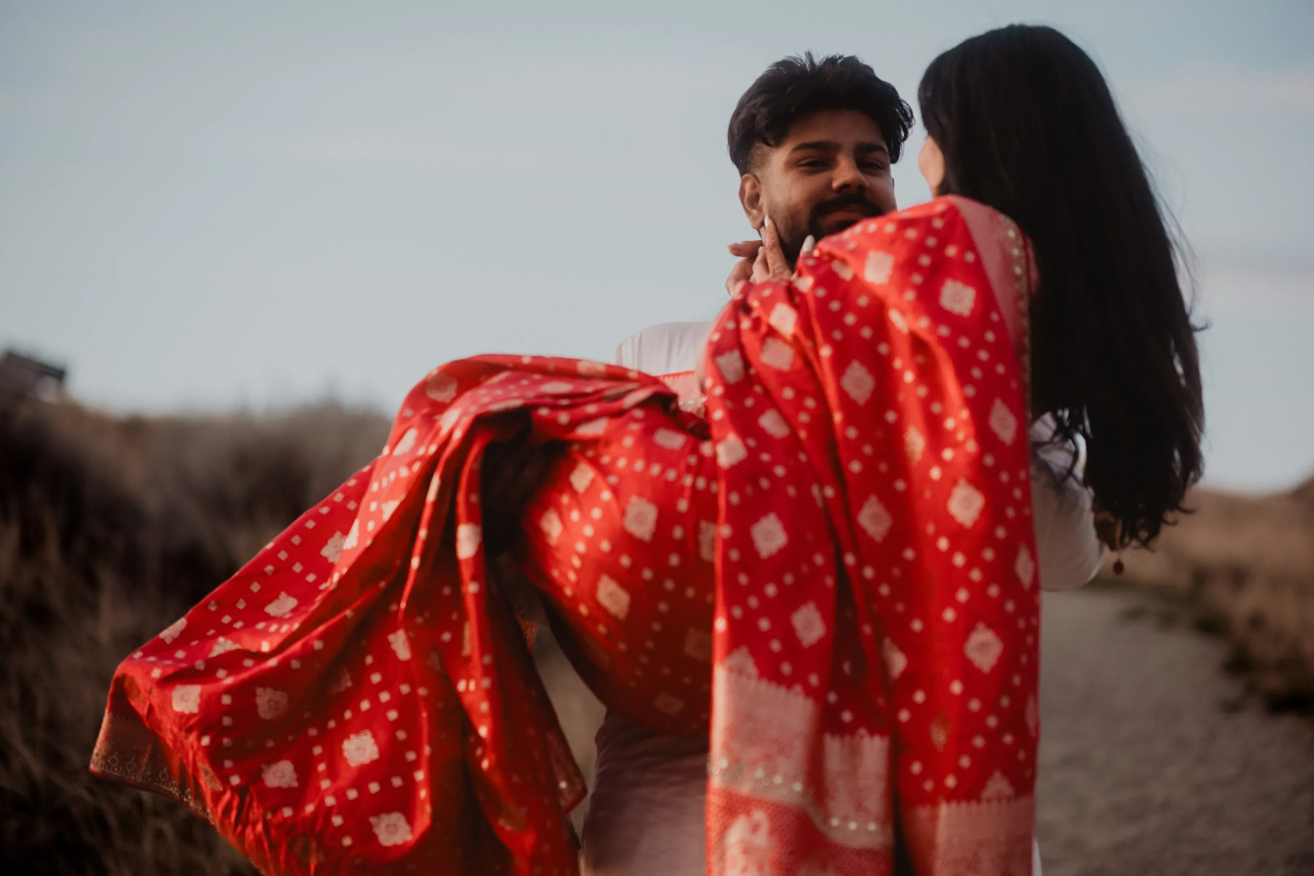 Kamal carrying Mehak in his white kurta, her red saree spilling across the path, by AD Photography