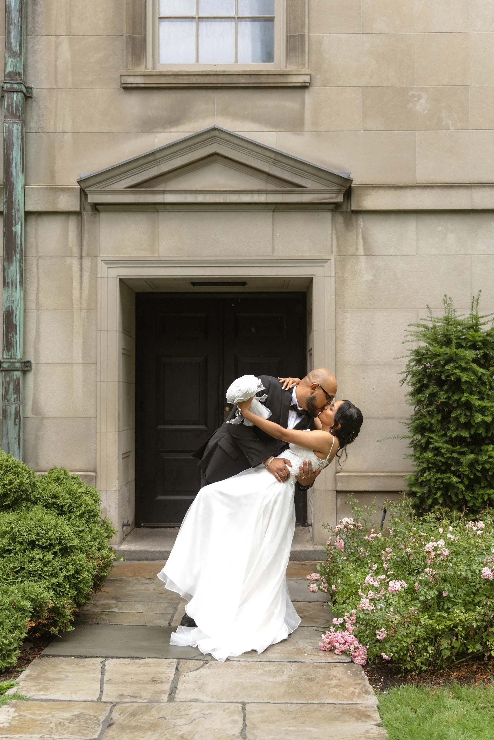 Groom dips the bride for a kiss on the Osgoode Hall garden path, by AD Photography
