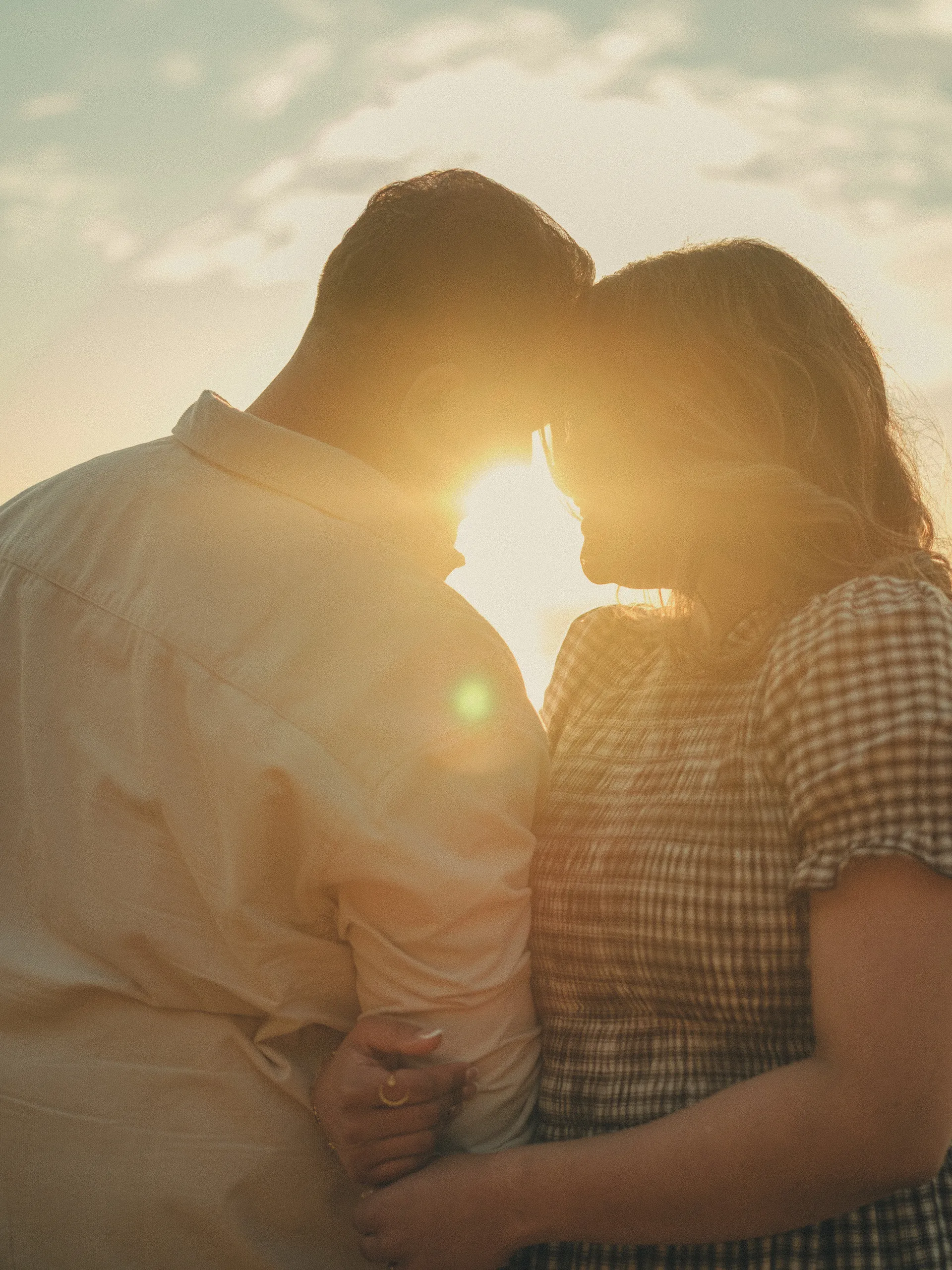 Maninder and Parneet forehead to forehead as the sunrise bursts through the gap between them, by AD Photography