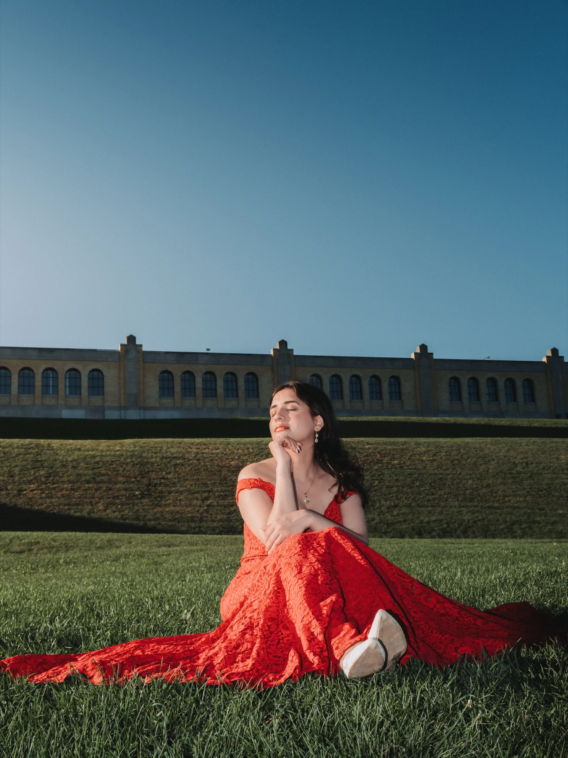 Solo portrait of Swati in red lace, eyes closed against the dusk blue arcade, by AD Photography