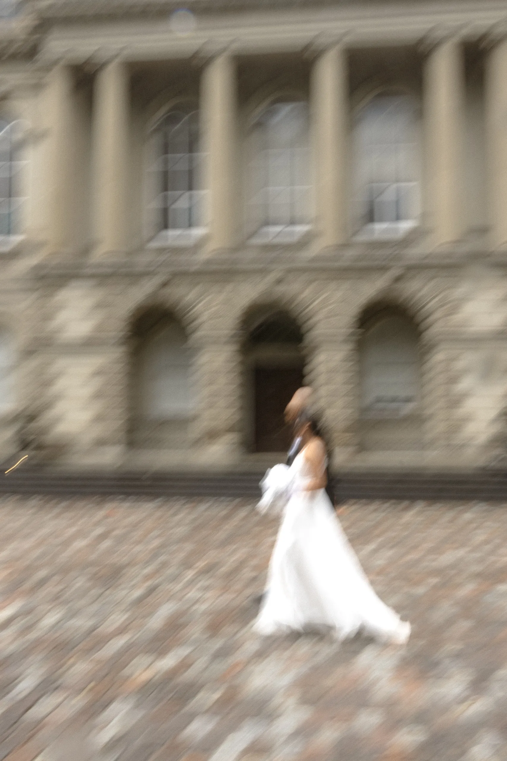 Motion blur of the bride turning on the Osgoode Hall cobblestones, by AD Photography
