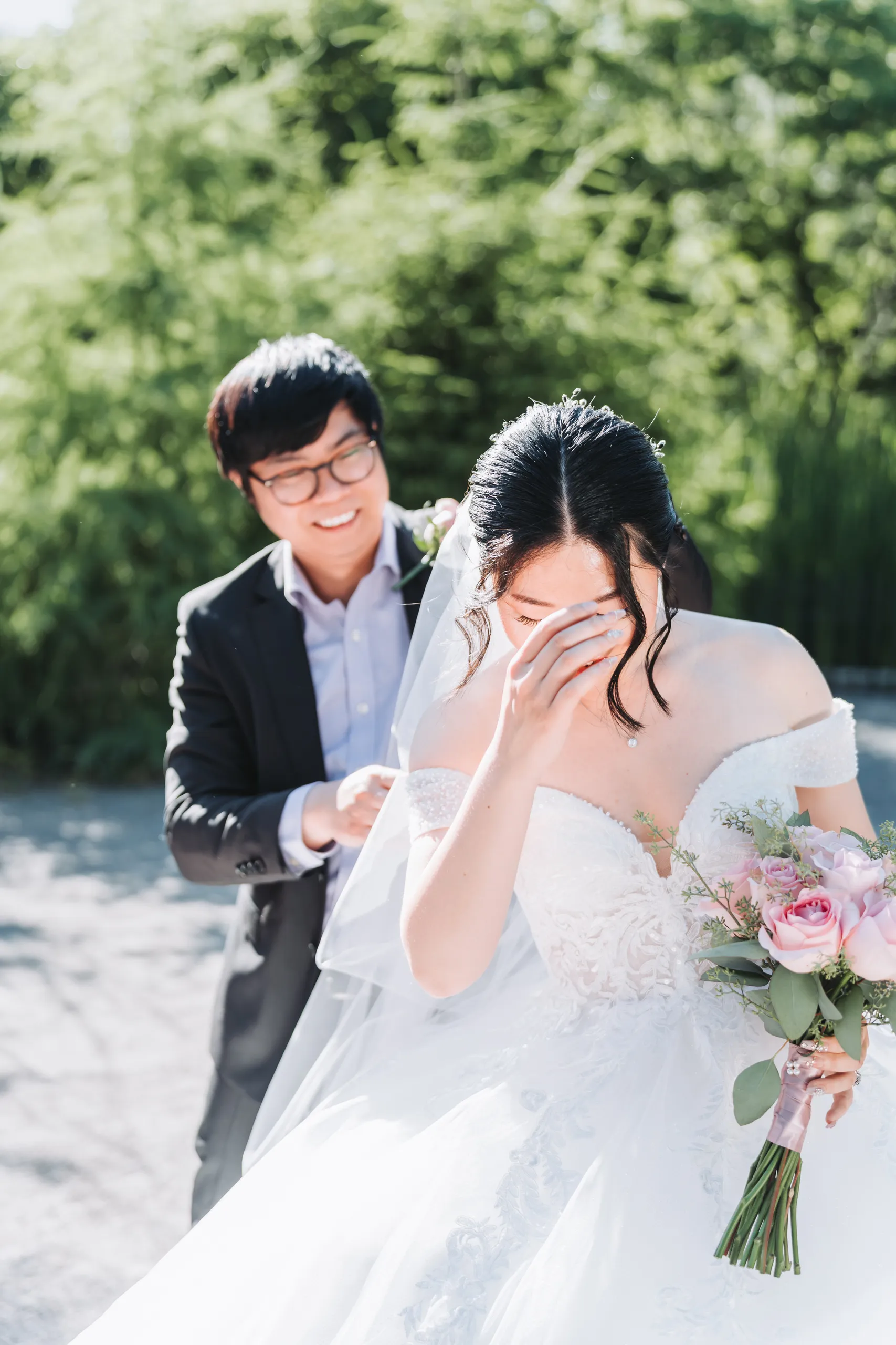 Micheal holding Karen's veil as she wipes away a tear after their garden ceremony in Niagara Falls, by AD Photography