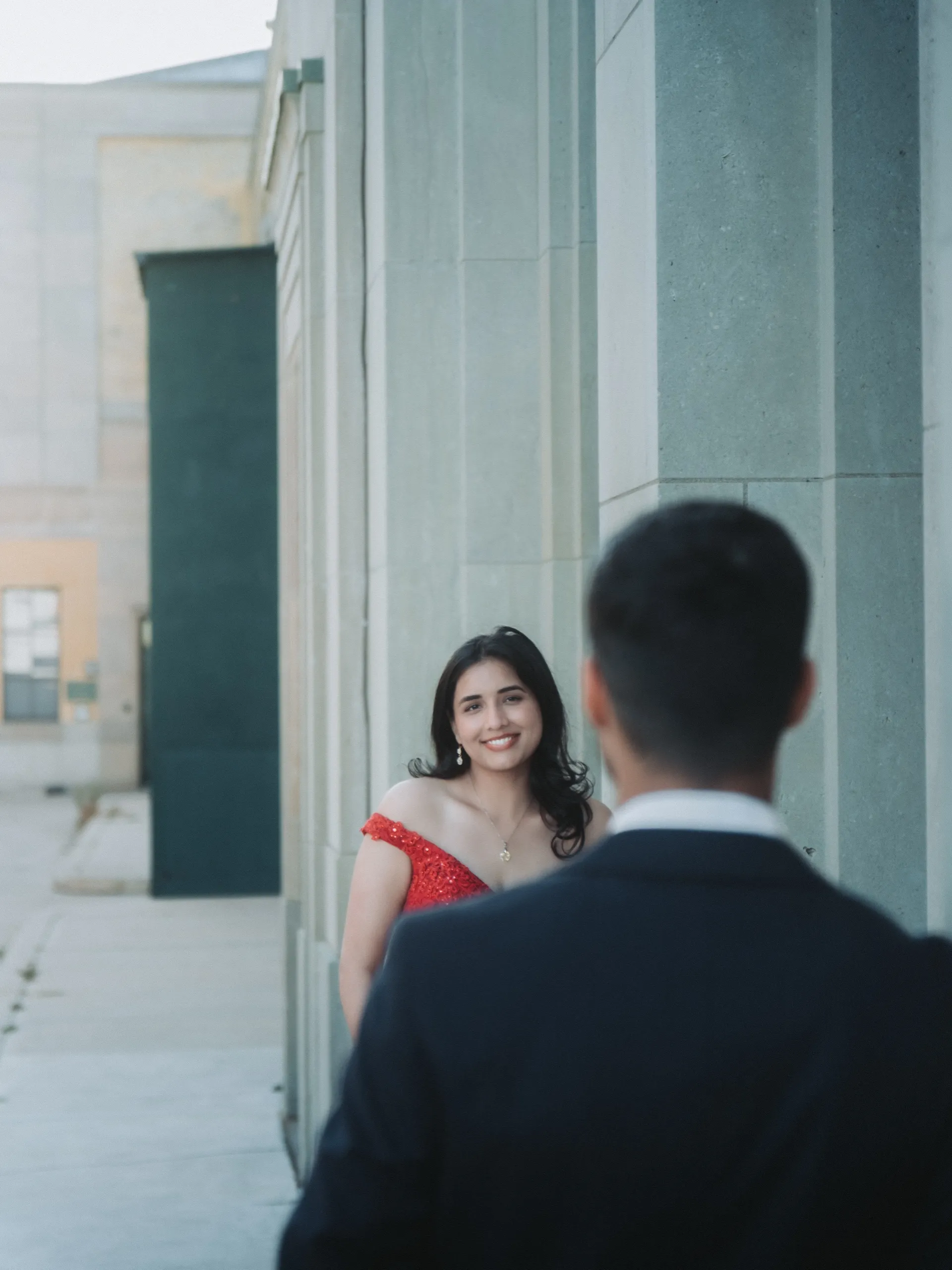 Swati smiles past Saksham's shoulder between the limestone columns of the water plant arcade, by AD Photography