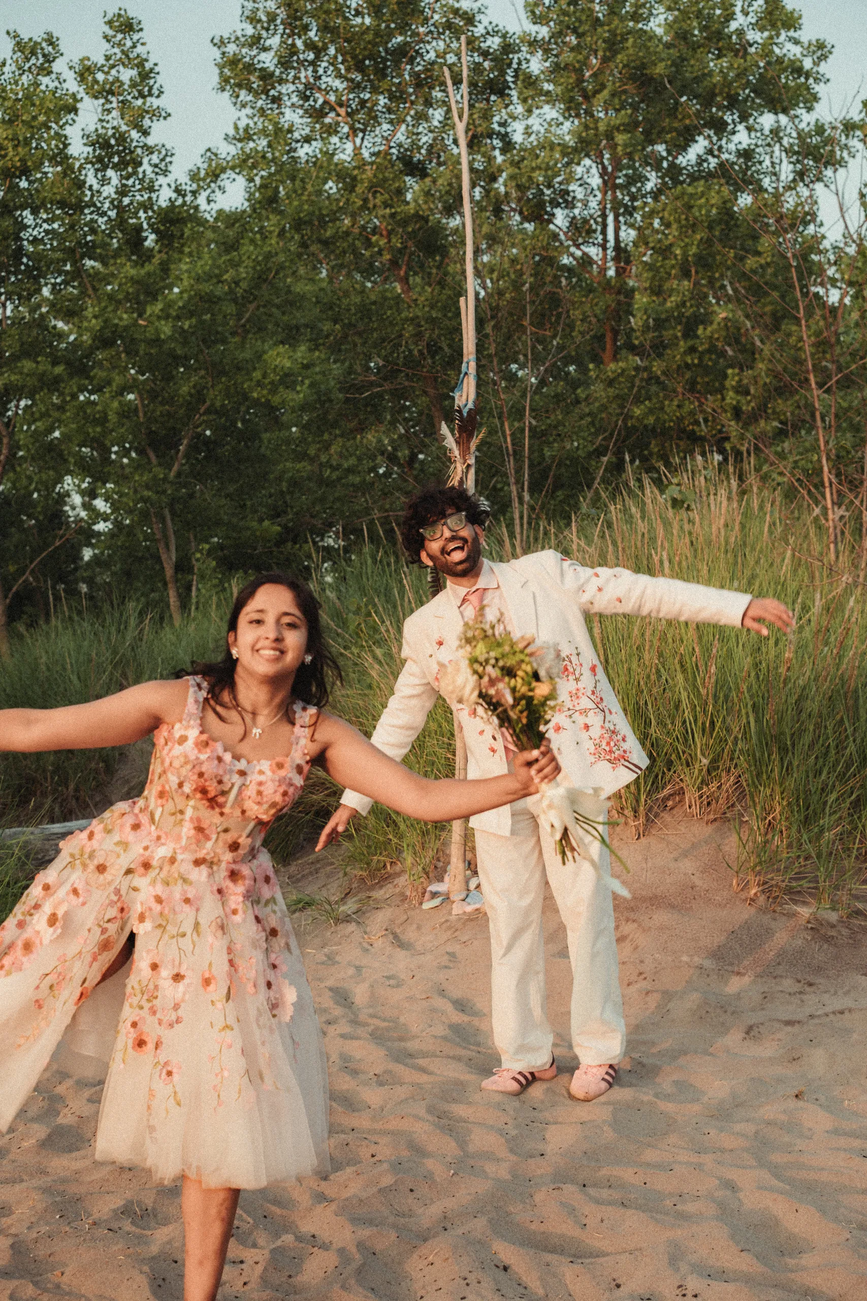 Payal with her arms spread wide, gown twirling, on the beach at the Toronto Islands, by AD Photography