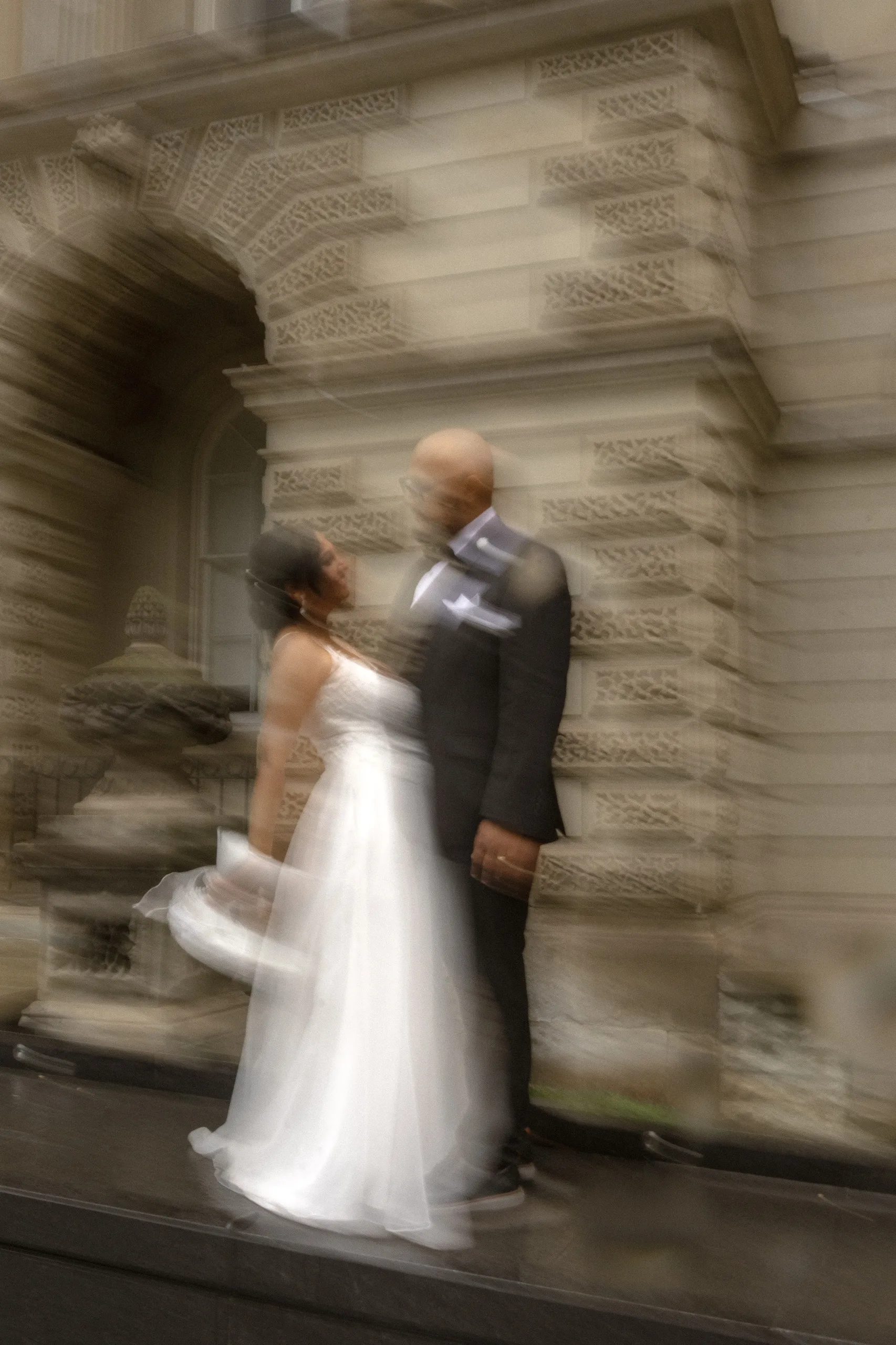 Motion blur of the bride's gown sweeping past the Osgoode Hall arches, by AD Photography