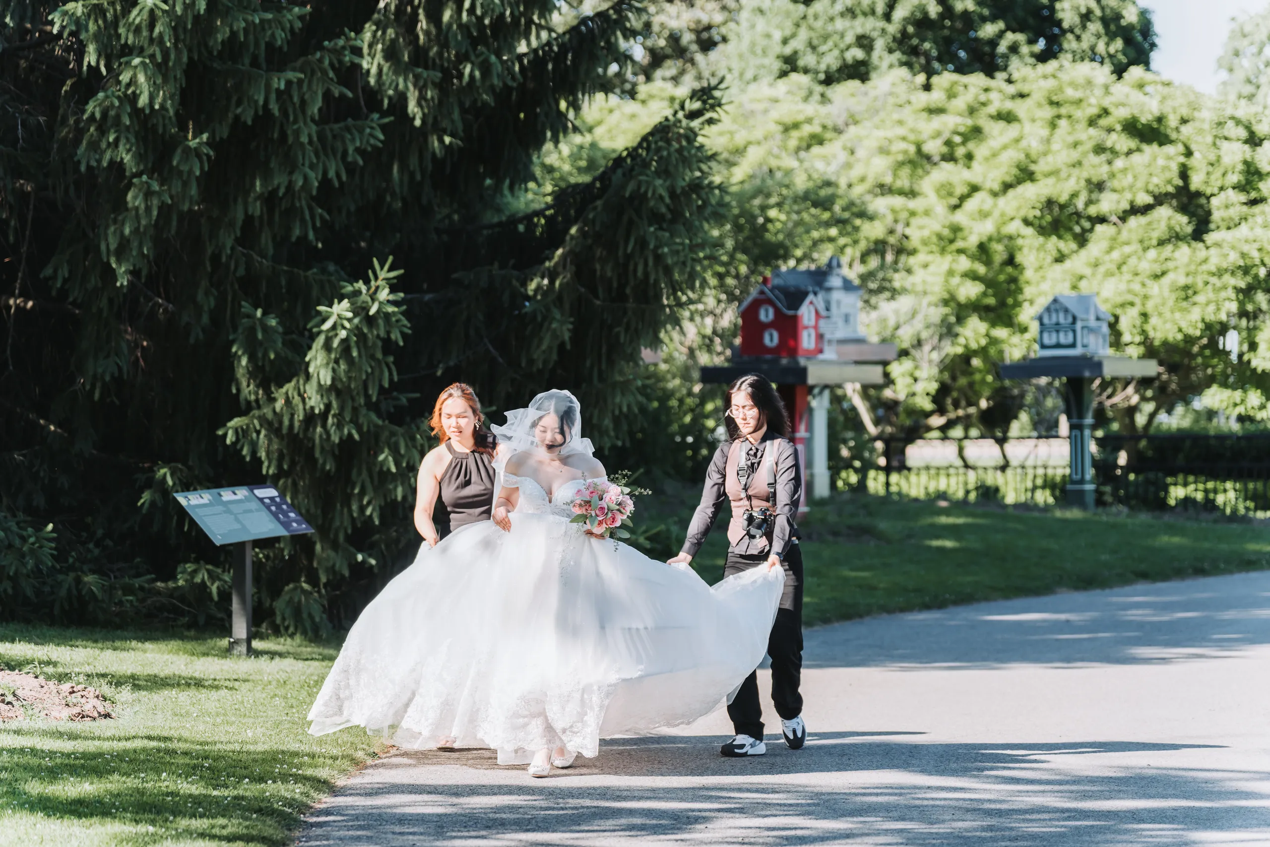 Karen mid stride with her gown fanned out along the garden path in Niagara Falls, by AD Photography