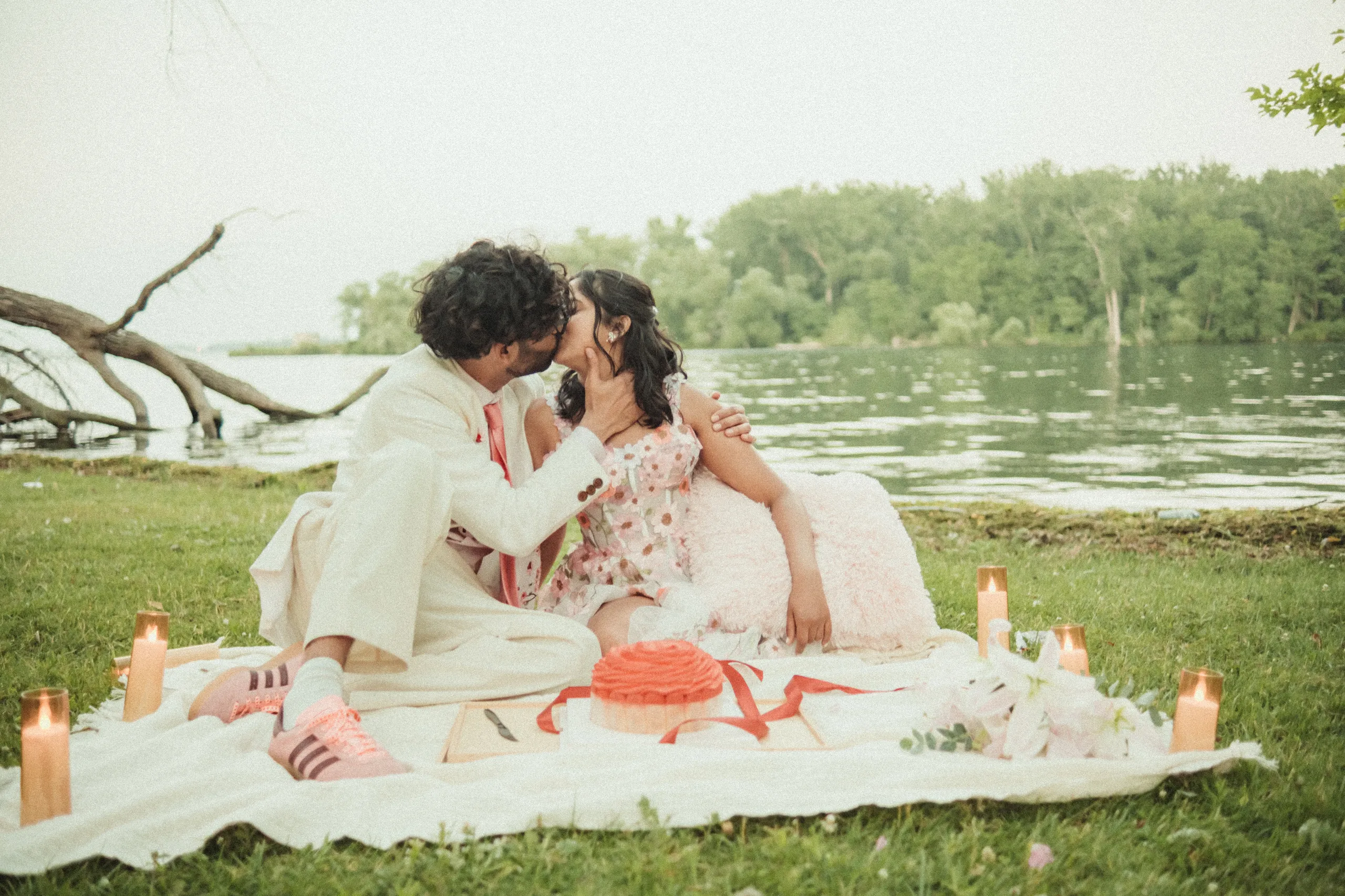 Harsh and Payal kissing at a candlelit lakeside picnic with their cake, Toronto Islands, by AD Photography