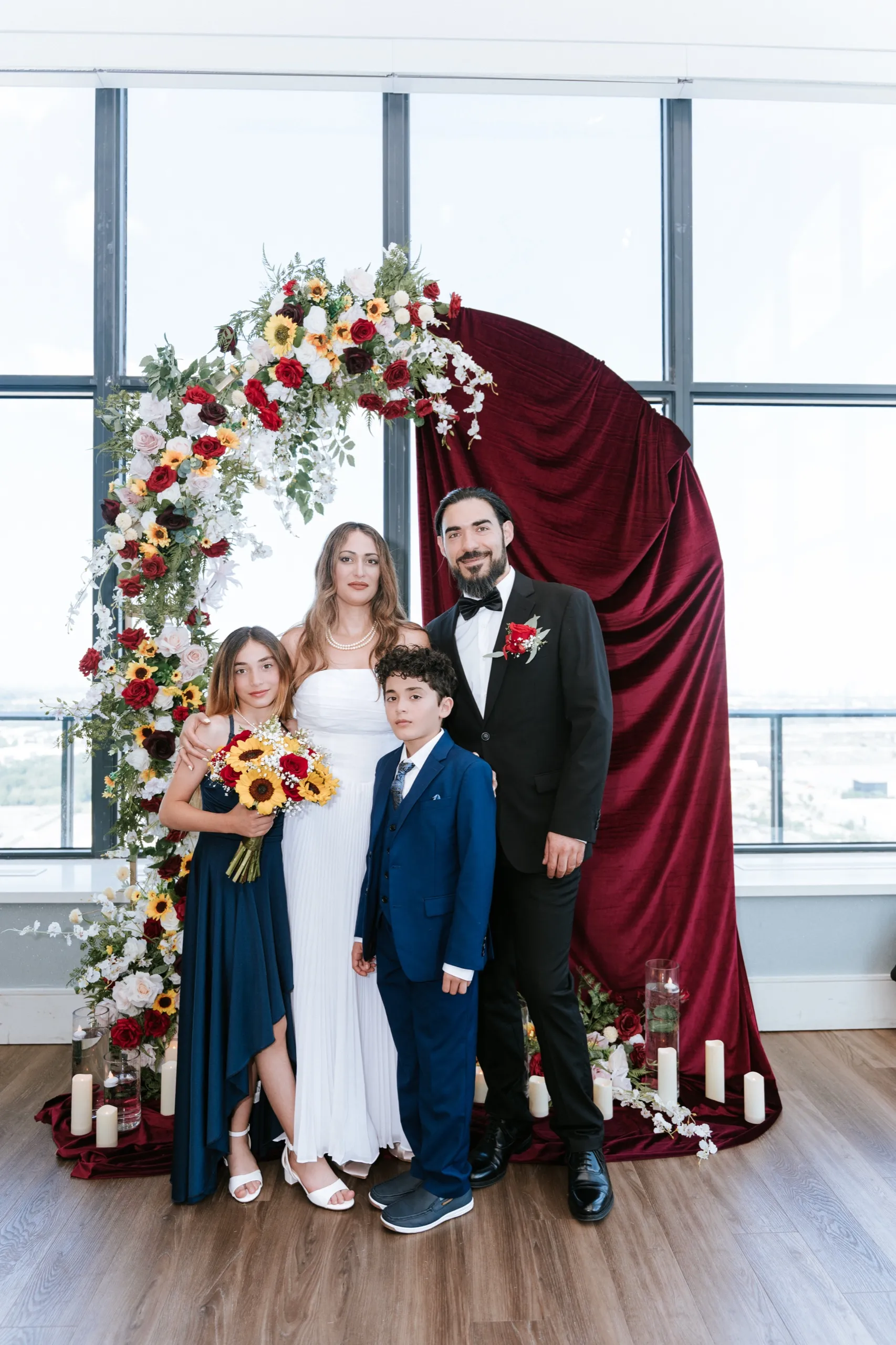 Zoha and Moe pose with two of the children in front of the sunflower arch, by AD Photography