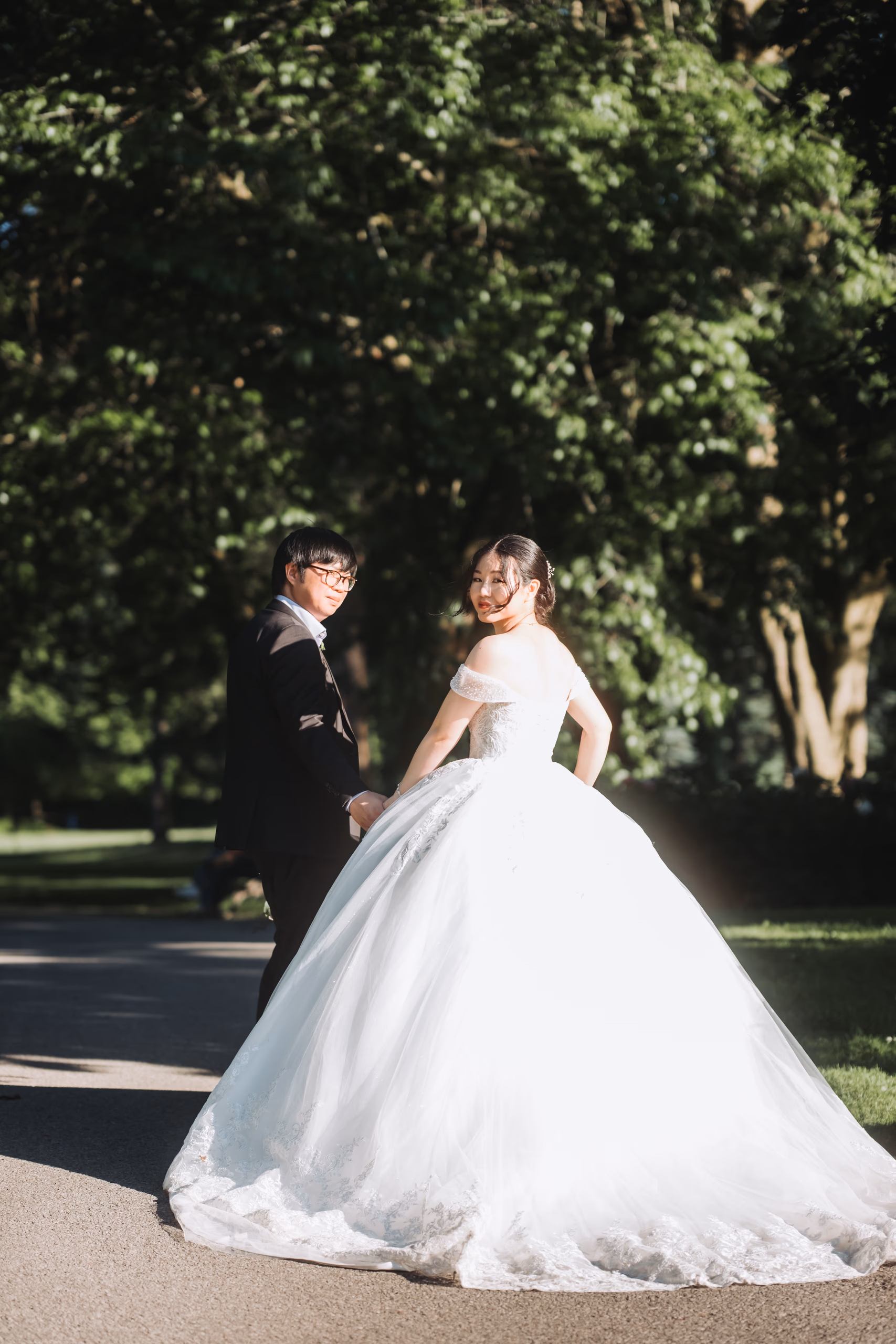 Karen glancing back over her shoulder in backlight on a tree lined path at the Niagara Parks Botanical Gardens, by AD Photography