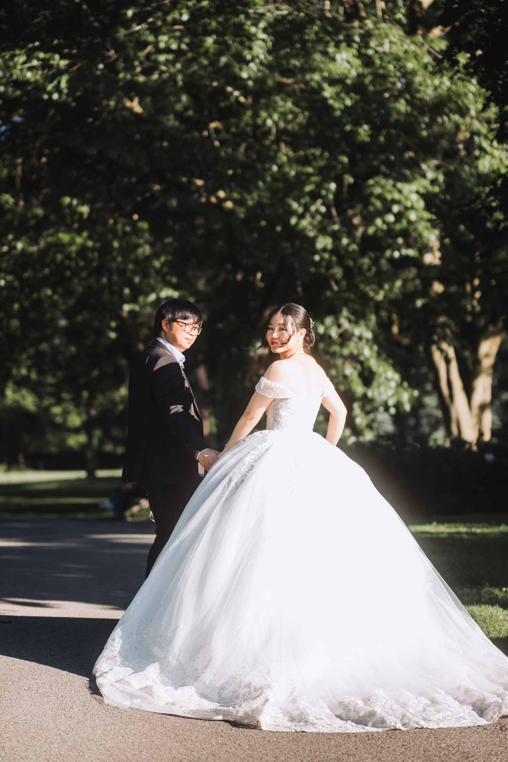Karen glancing back over her shoulder in backlight on a tree lined path at the Niagara Parks Botanical Gardens, by AD Photography