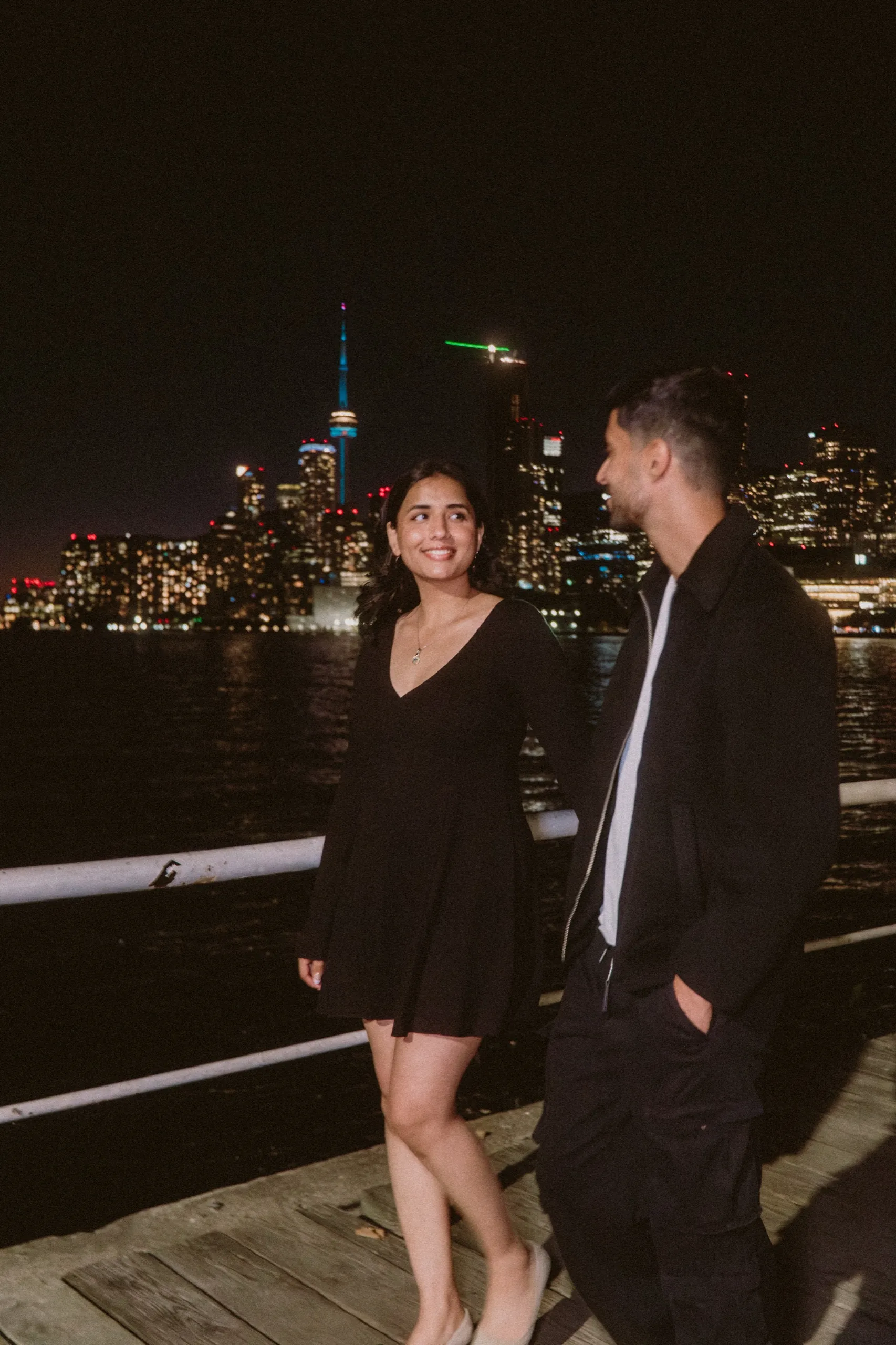 Flash lit stroll along the boardwalk, the downtown towers glowing behind them, by AD Photography