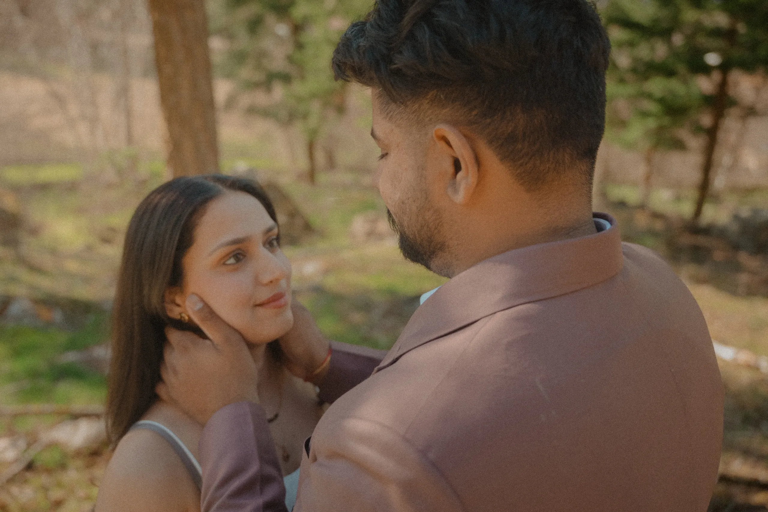 Soft focus frame of Kamal holding Mehak's face while she looks up at him, by AD Photography