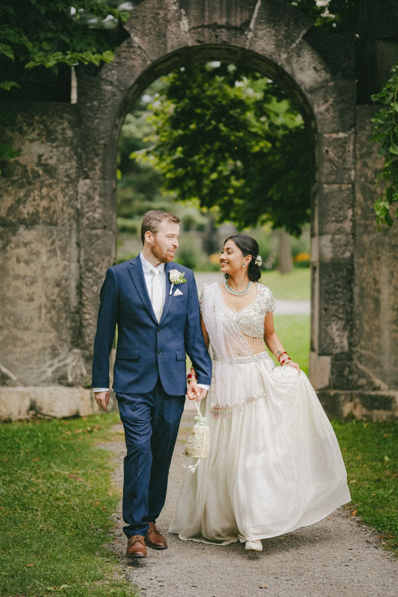 The newlyweds share a look walking through the old stone gateway at Guild Park and Gardens, by AD Photography