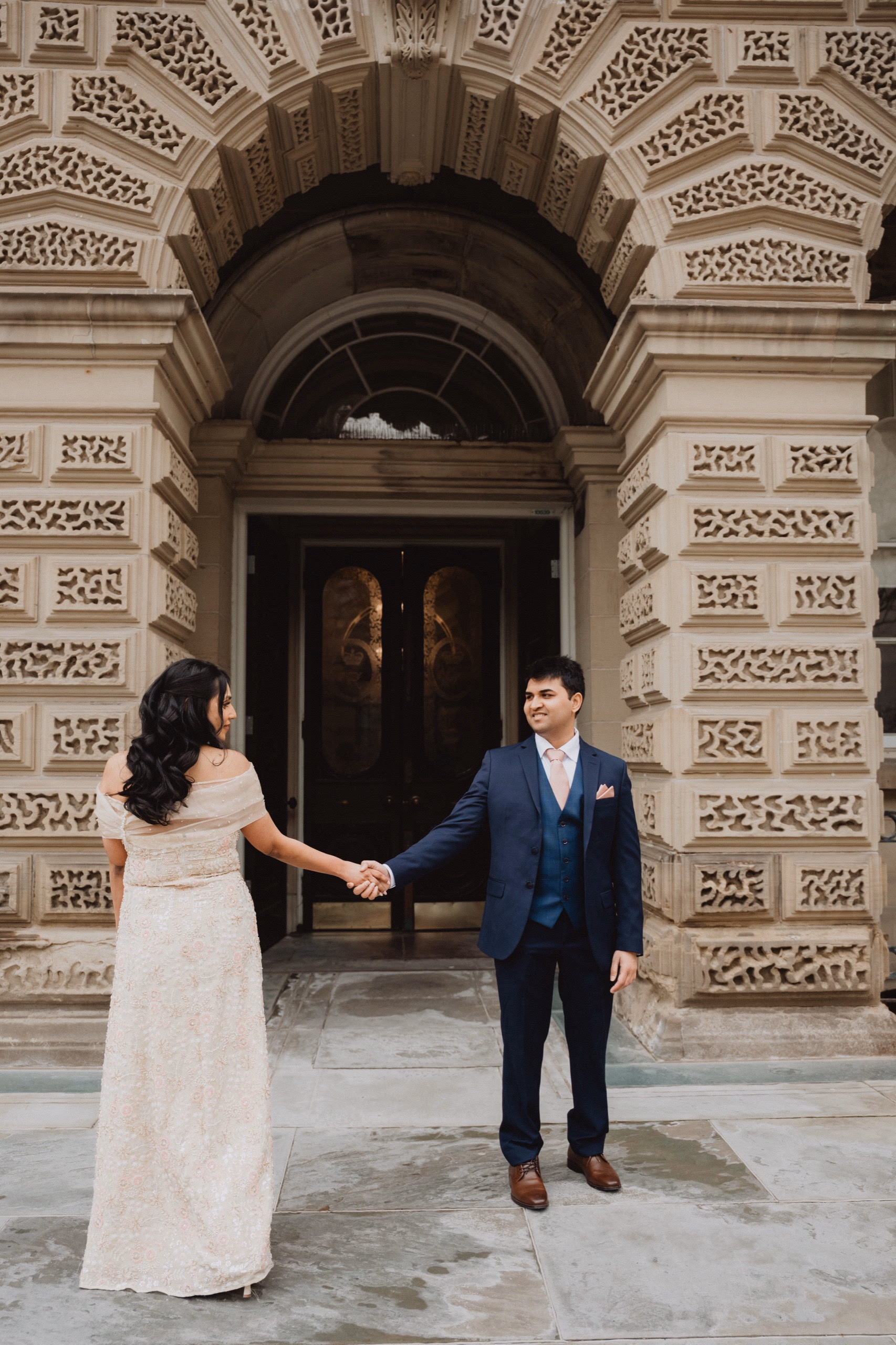 Achyut draws Sonia toward him beneath the grand carved archway