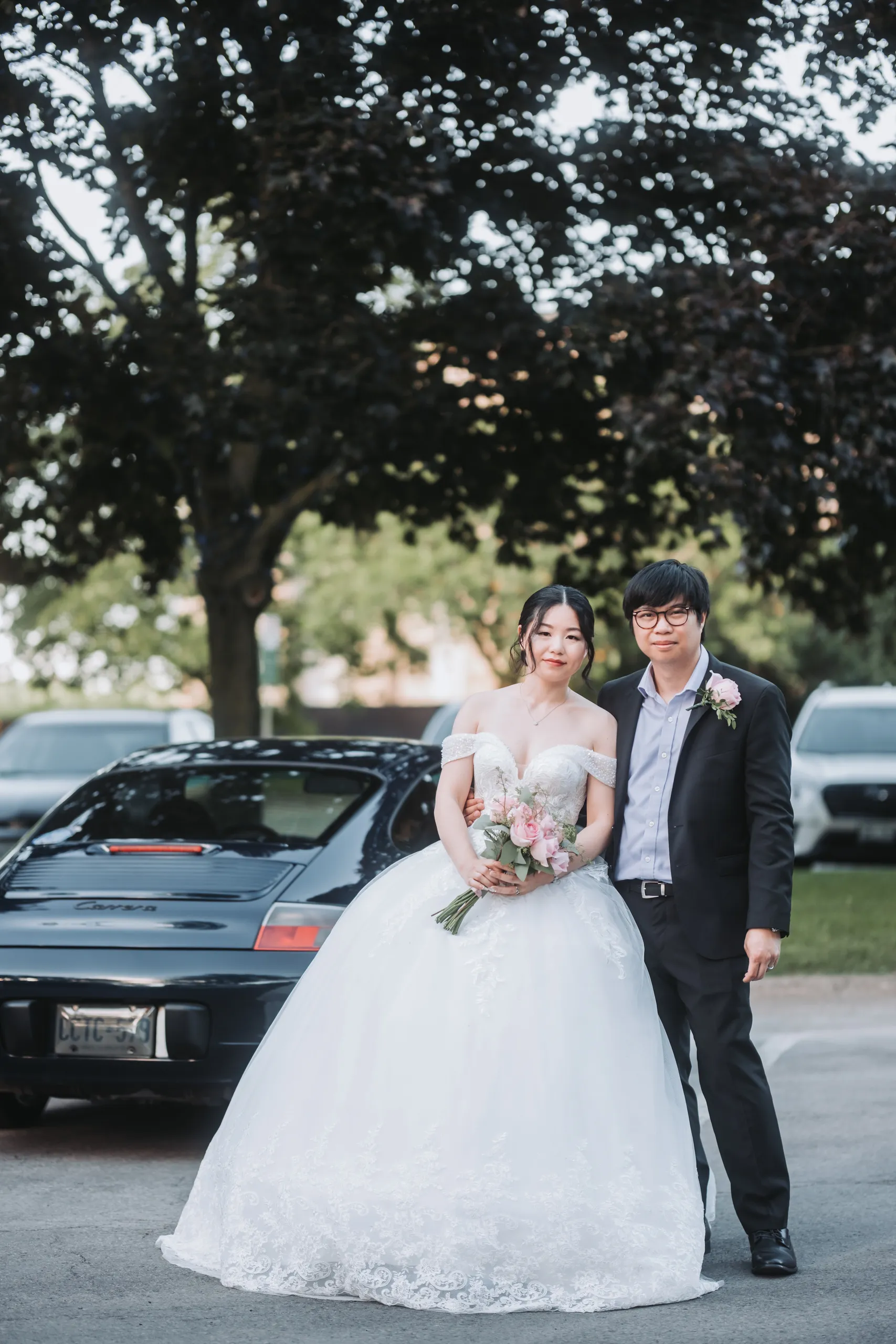 Karen and Micheal beside a black sports car at the end of their Niagara Falls wedding day, by AD Photography