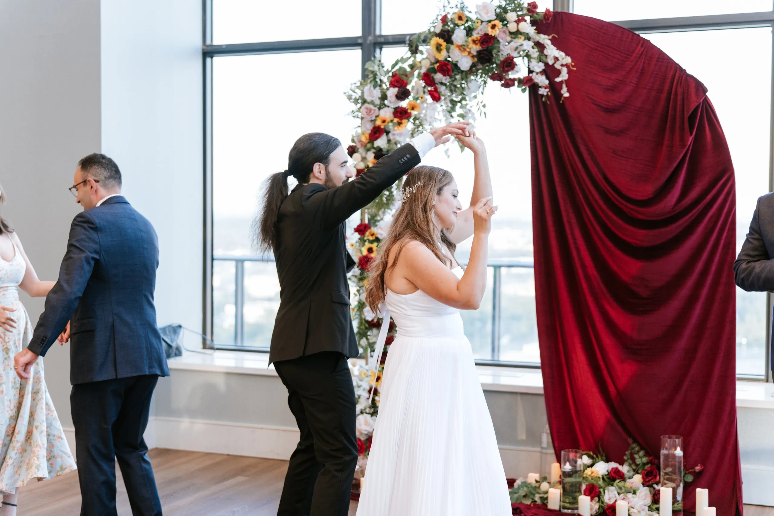 Moe spins Zoha under his arm in front of the sunflower arch and candles, by AD Photography