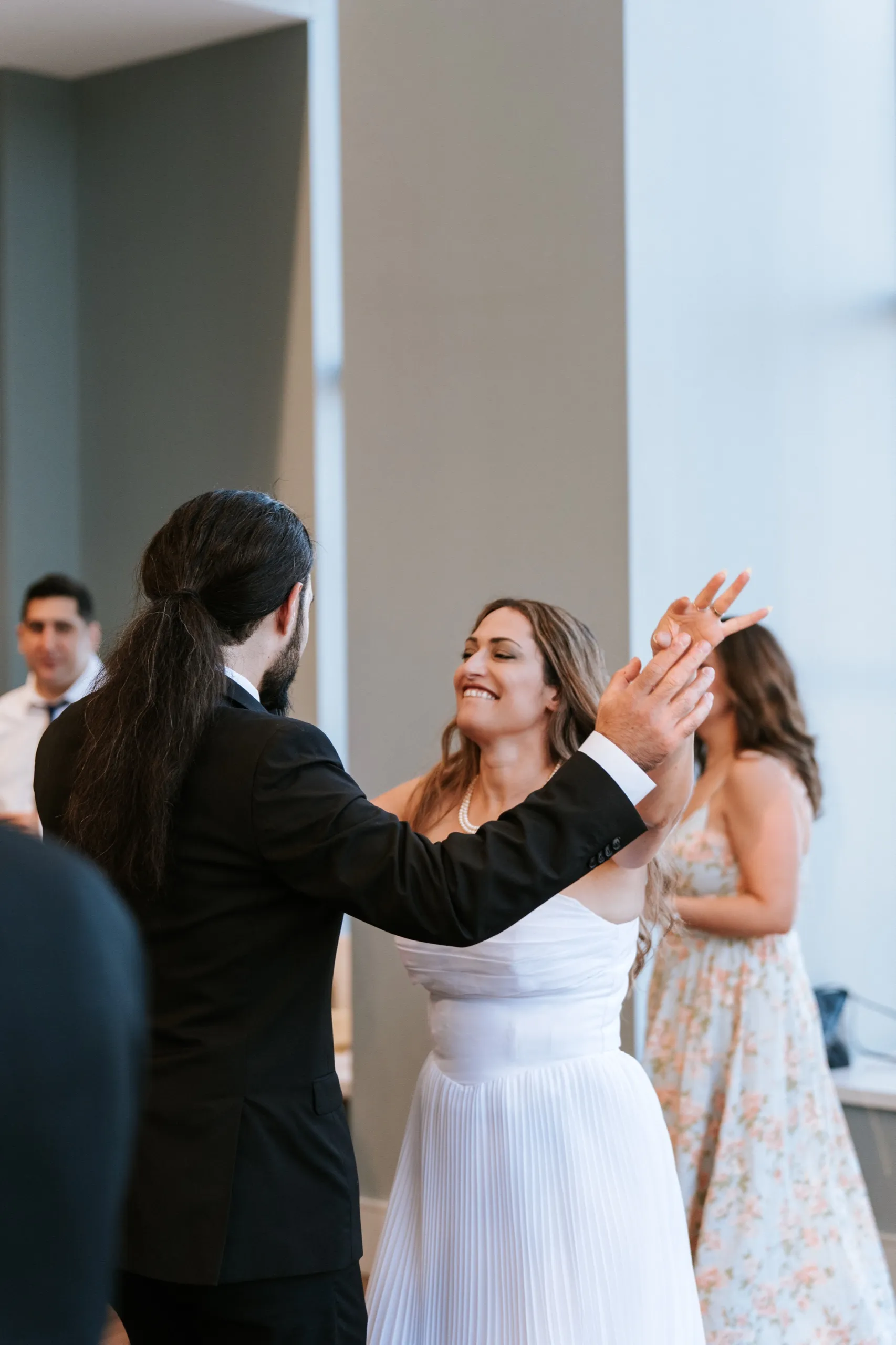 Moe and Zoha dance with hands raised together, both of them laughing, by AD Photography