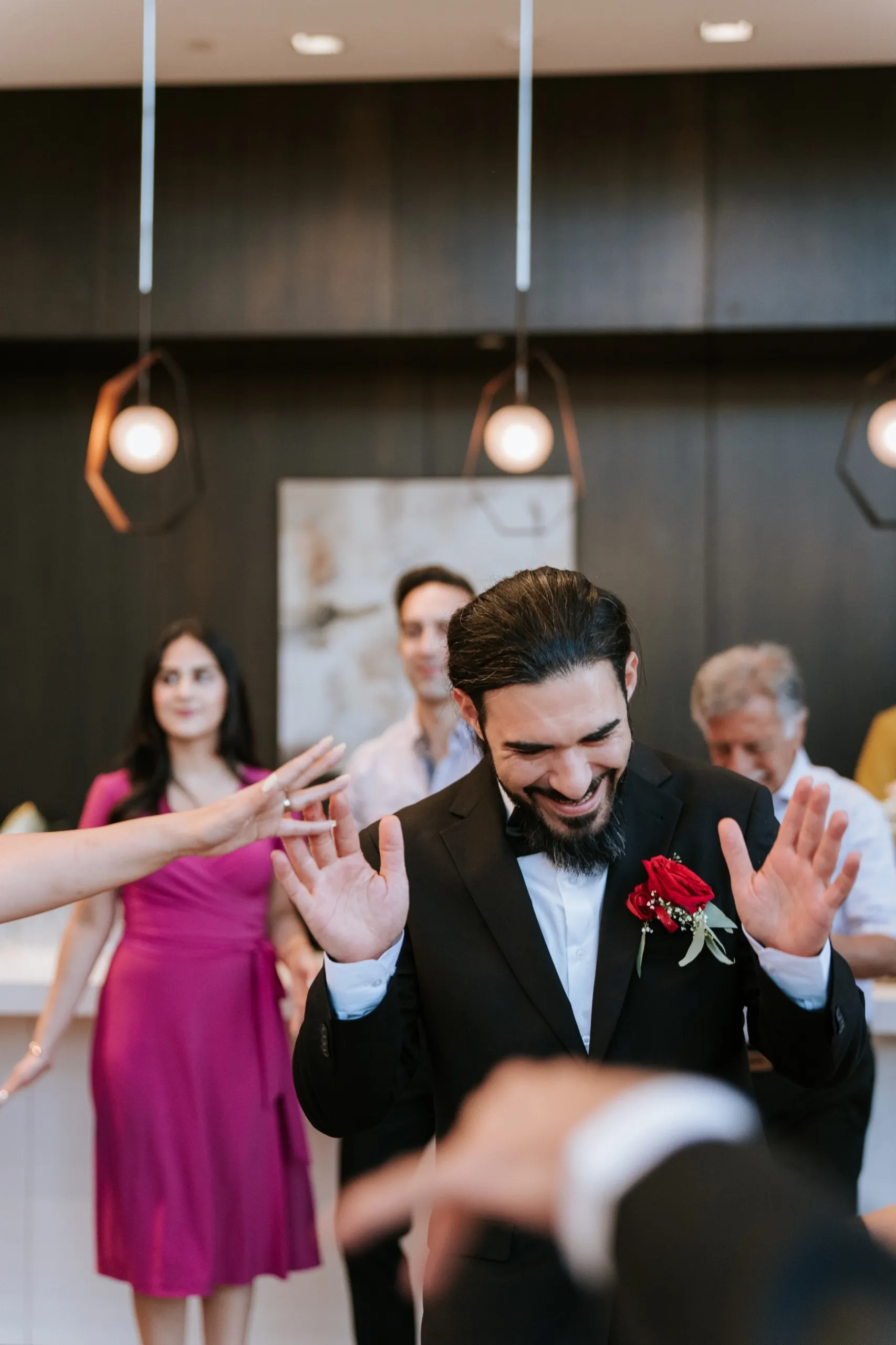 Moe in the middle of the circle, head down laughing while everyone claps, by AD Photography
