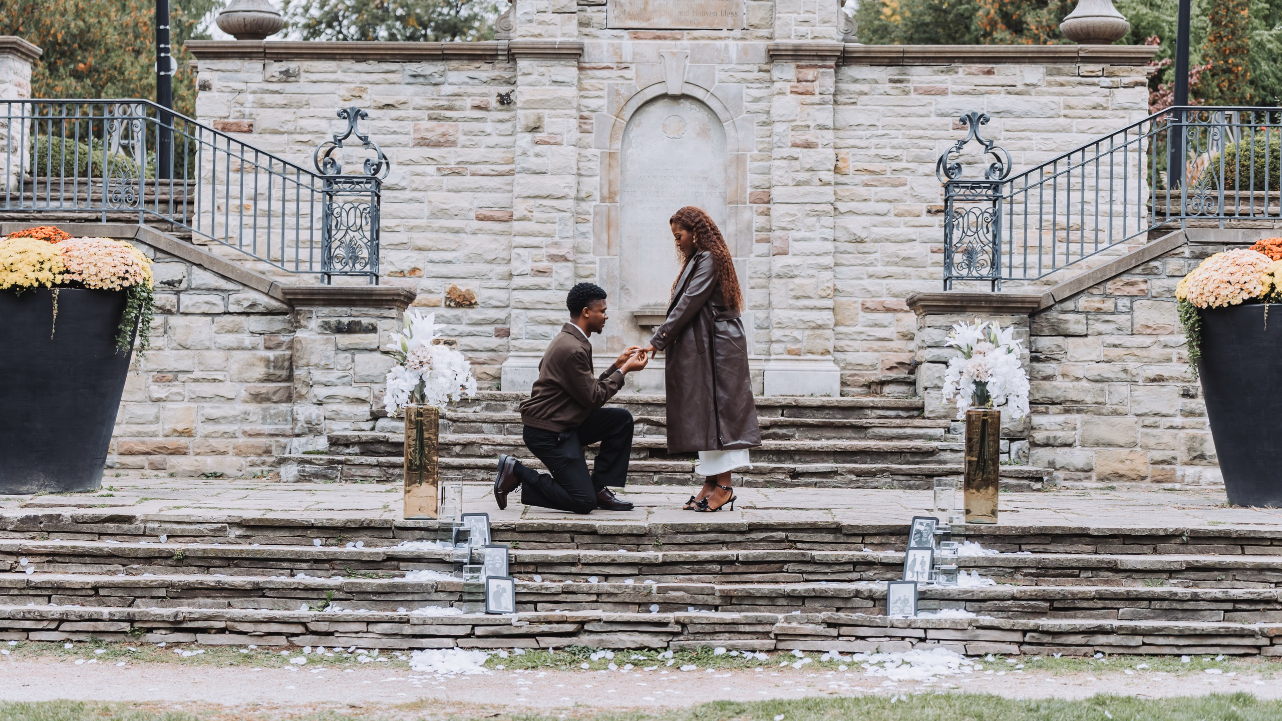 Richie on one knee proposing to Aimee on the stone terrace steps at Alexander Muir Memorial Gardens in Toronto, by AD Photography