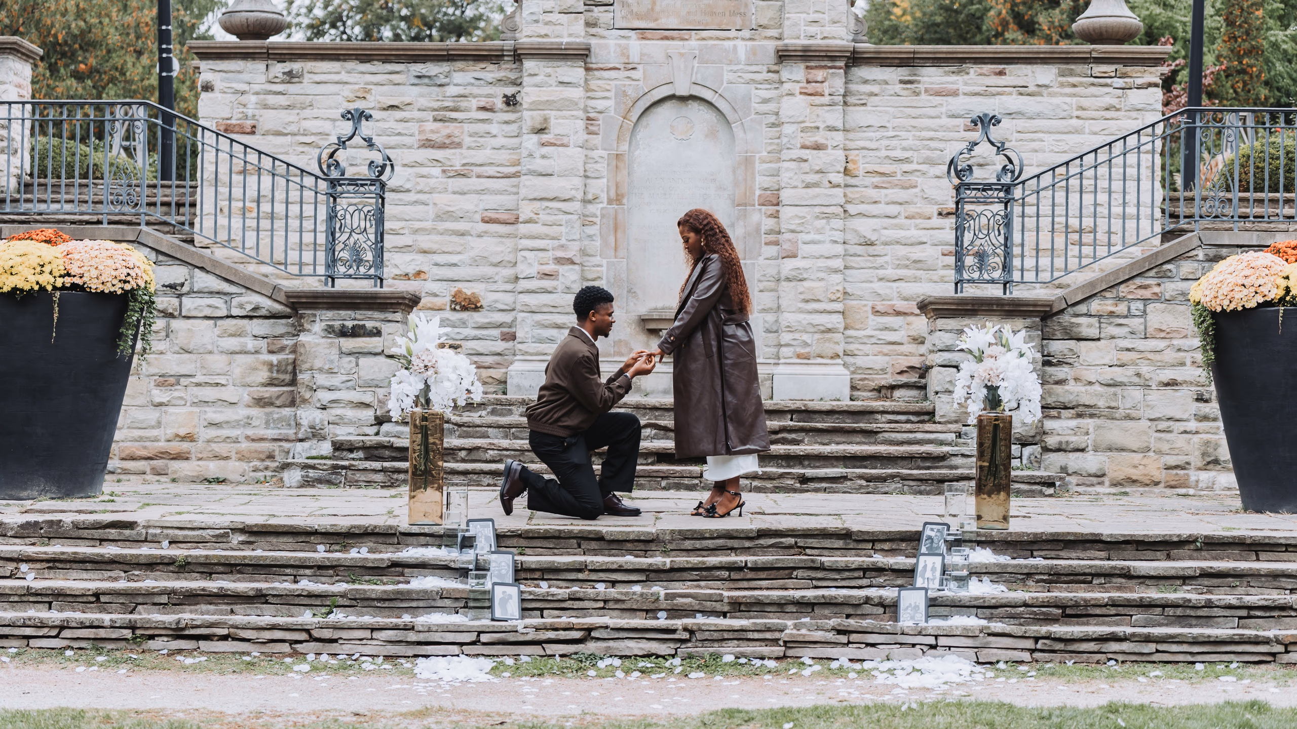 Richie on one knee proposing to Aimee on the stone terrace steps at Alexander Muir Memorial Gardens in Toronto, by AD Photography